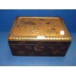A black lacquered Box with gilt decoration including embossed figures to lid,