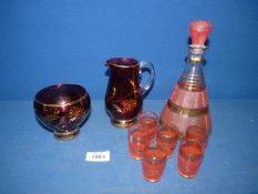 A pretty pink/gold decanter and 6 shot glasses, together with a glass lustre jug and sugar bowl.