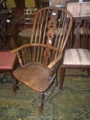 An appealing solid Elm seated kitchen Elbow Chair having fretworked central splat and stick back,