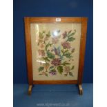 A tapestry Fire-screen depicting a colourful bird amongst similarly coloured flowers,