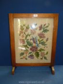 A tapestry Fire-screen depicting a colourful bird amongst similarly coloured flowers,