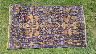 A blue ground natural dyed Eastern Rug decorated with flowers and animals, 132 cm long x 73 cm.