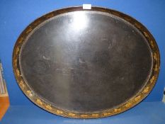A large oval black papier mache serving tray, gilt foliage detail to sides of tray,