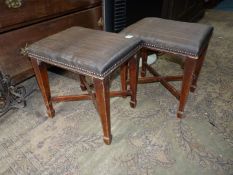 A pair of Mahogany framed rectangular Stools having dark fabric upholstered tops,