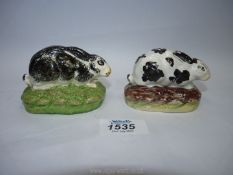 Two Staffordshire Rabbits, one white with black spots with red mark to base, some hairline cracks,