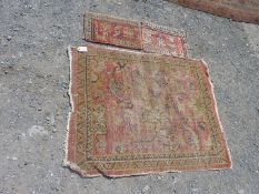 A small red ground Rug with floral motif, worn and faded,