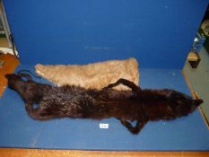 A brown fox fur stole and a light brown fur stole.