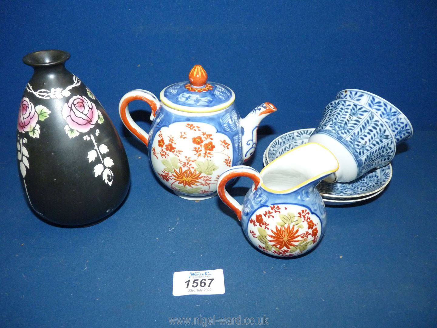 A vintage porcelain miniature teapot and a matching milk jug,