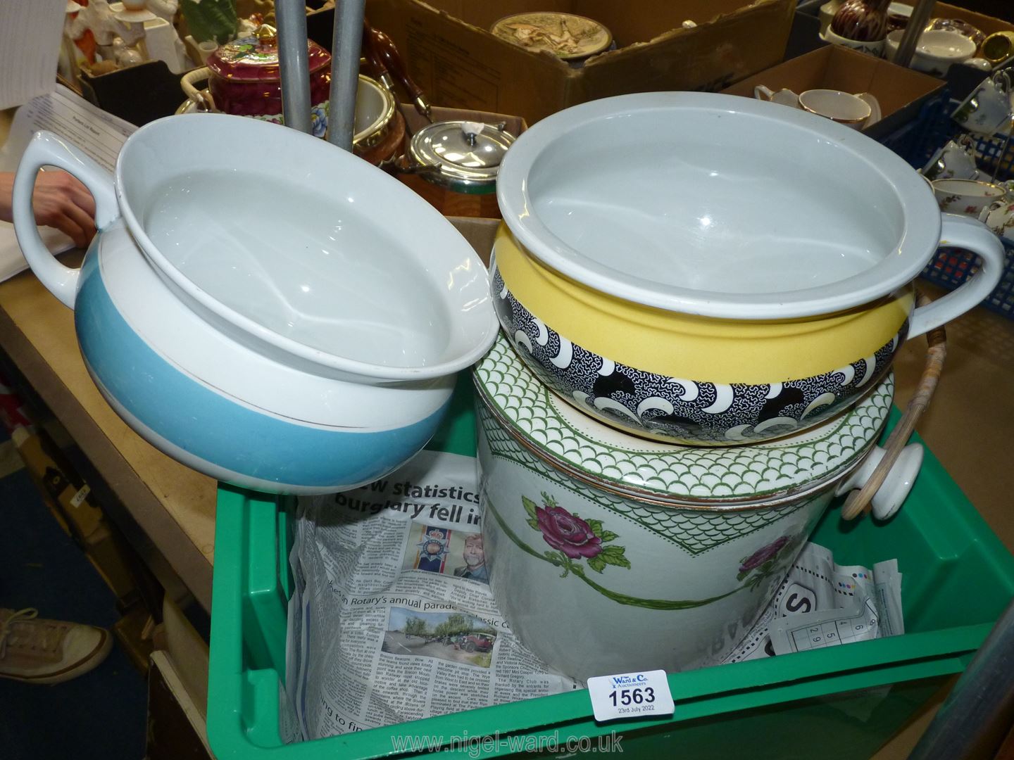 A lidded washstand bucket with handle having a rose decoration and two chamber pots.