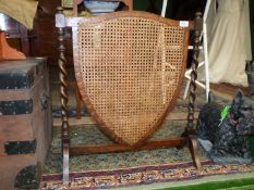 A 1930's shield shaped cane work Fire-screen.