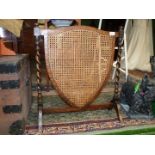 A 1930's shield shaped cane work Fire-screen.