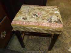 A well worn tapestry seated darkwood framed Stool having an ''H'' stretcher,