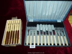 A cased set of six fish knives and forks and a boxed set of six stainless steel knives with wooden