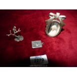 A silver stamp holder in the form of a letter,