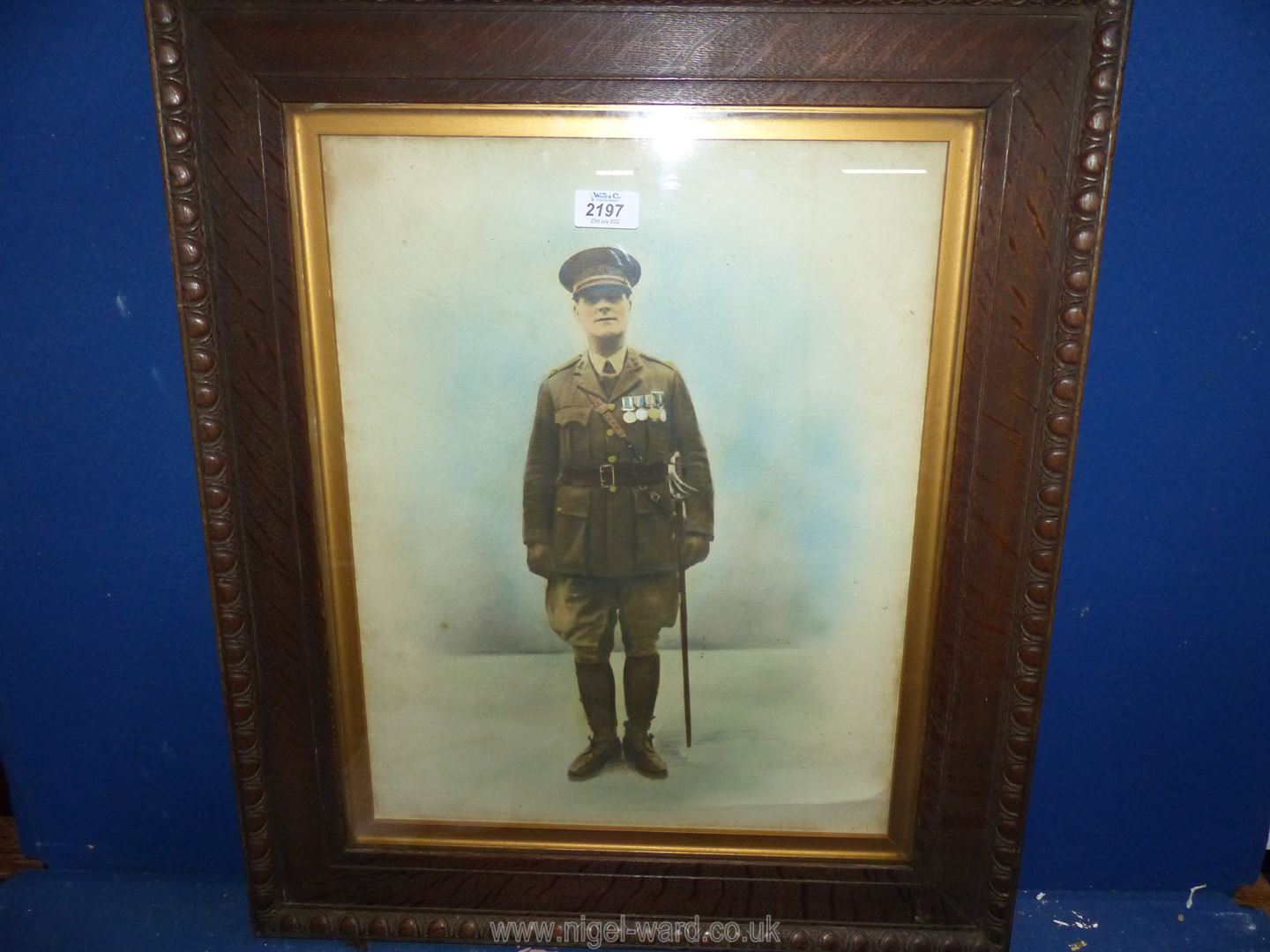 A carved wooden framed coloured Lithograph of a military officer.
