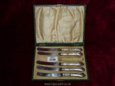 A boxed set of five silver handled butter knives- one missing- Sheffield 1918 to maker John Biggin-