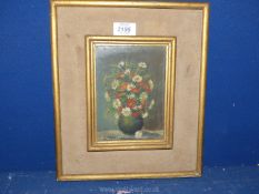 A small framed Oil on board depicting a vase of flowers, indistinctly signed lower left.