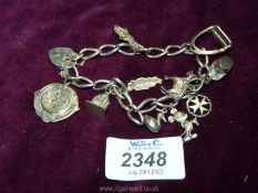 A silver Charm bracelet, plus charms to include medal 1952, London silver locket 1978, Mickey Mouse,