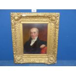 An ornate gilt framed oil on board depicting a three quarter portrait of a gentleman sat in a red