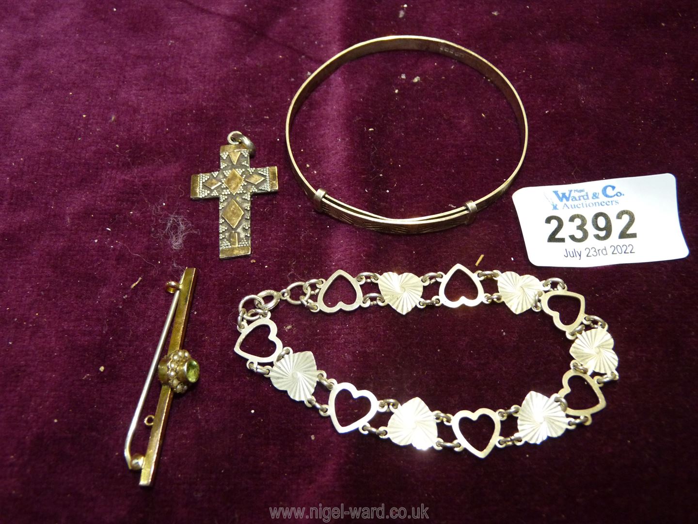 A 9ct gold bar brooch, silver christening bangle, crucifix and sterling silver hearts bracelet.