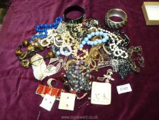 A yellow basket of costume jewellery including beads, bangles, shells etc.