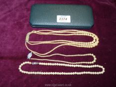 Three cultured pearl necklaces including single and triple strand.