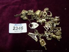 A silver Charm bracelet with charms to include a church, a t.v., a clock, a cow, a rabbit, etc.