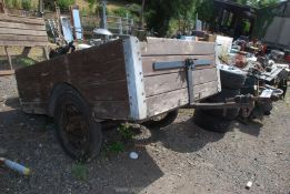 An old wooden trailer with Austin 7 type spoked wheels, a/f., base approx. 82" x 56".