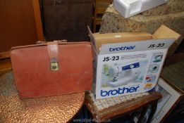 A Brother JS-23 sewing machine, hardly used, (boxed) and a leather briefcase.