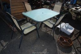 A glass topped patio table with 4 chairs (one a/f), 55 1/2" x 3ft x 27" high.