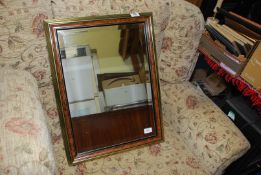 A bevelled edge gilt and walnut effect mirror.