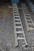 A thirteen rung double extension aluminium ladder.