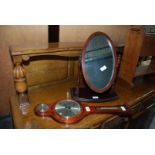 A small banjo style barometer and an oval dressing table mirror.