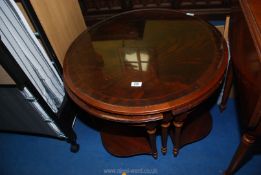 A round coffee table with glass top and four corner tables.