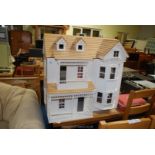 A large three storey open fronted dolls house, 32" x 31" x 19" (no furniture).