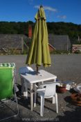 A plastic patio table, 2 chairs and a parasol.