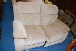 A two seater beige reclining sofa.