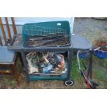 A green wheeled barbecue with charcoal, etc.