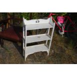 A white painted free standing shelf unit, 21 1/2" wide x 35" high x 8" deep.