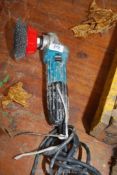 A Makita angle grinder with wire brush attachment. (needs guard prior to use.