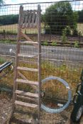 A roll of galvanised fencing wire and a six rung wooden step ladder.