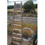 A roll of galvanised fencing wire and a six rung wooden step ladder.
