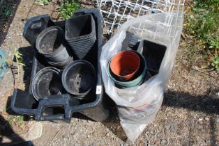 A bag and a large box of plastic pots and plant trays.