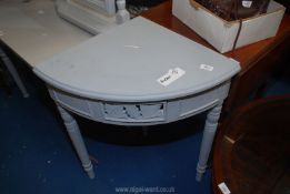A grey painted corner table with drawer.