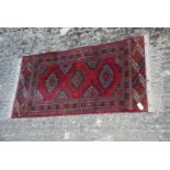 A red and green prayer rug with fringing, 40" x 20".