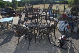 A circular aluminium table, 59" diameter x 29" high with six matching chairs.