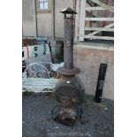 A cast iron chiminea with barbecue shelf and chimney,