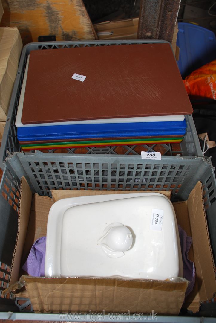 A quantity of coloured chopping boards and a large cheese dish.