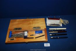 Two Parker pens with 14 k nibs, Waterman refills, Osmiroid, etc., in a wooden cribbage board/ box.