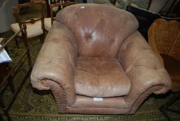 A large Thomas Lloyd leather upholstered Armchair having buttoning to the back and arms and brass